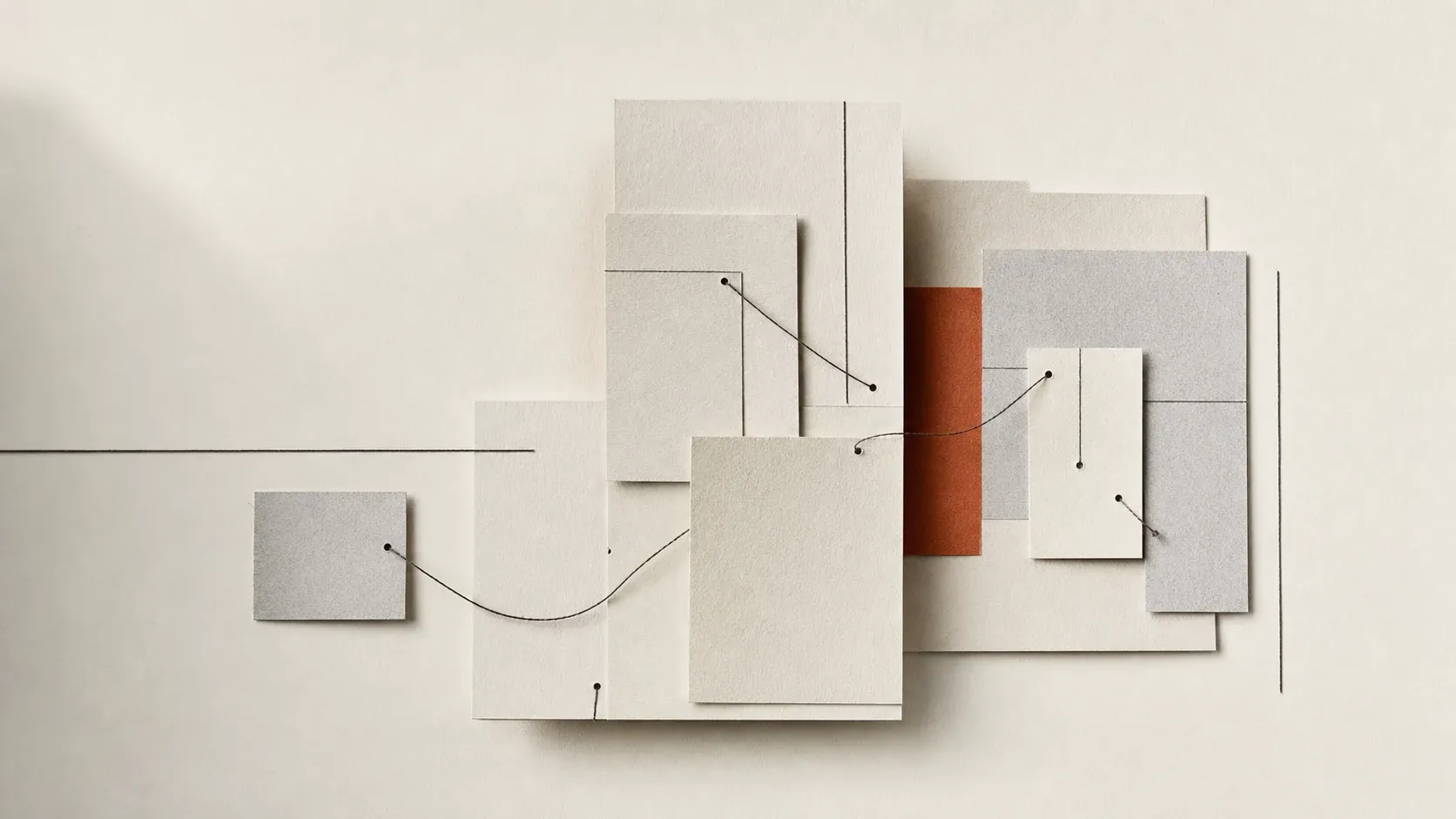 Layered cream paper cards connected by fine dark threads around a terracotta strip.
